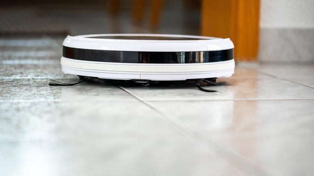 Reinigungskraft saugt ein Wohnzimmer