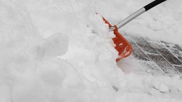 Schneeschaufel auf einem verschneiten Gehsteig
